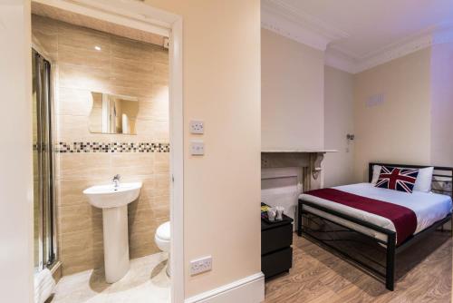 a bedroom with a bed and a sink and a toilet at Melandre Hotel By Saba in London