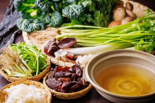 a table topped with baskets of vegetables and a bowl of soup at Sendai Kokusai Hotel in Sendai