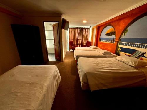 a hotel room with three beds in a room at Hotel Berlina in La Paz