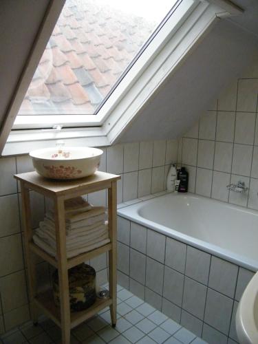 a bathroom with a skylight and a sink and a tub at La Perle Apartment in Utrecht