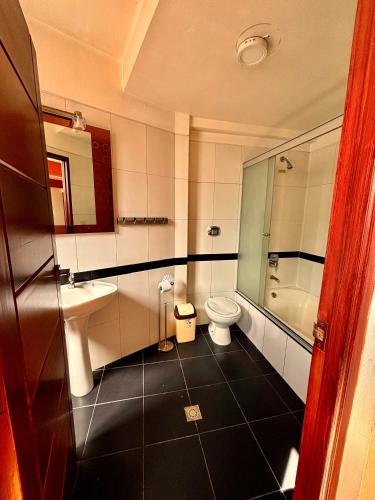 a bathroom with a toilet and a sink and a shower at Hotel Berlina in La Paz