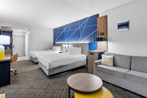 a hotel room with two beds and a couch at Comfort Inn & Suites FtJackson Maingate in Columbia