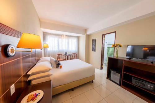 a hotel room with a bed and a flat screen tv at Hotel Faranda Express Soloy and Casino, a member of Radisson Individuals in Panama City