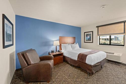 a hotel room with a bed and a chair at MainStay Suites Spokane Valley in Spokane Valley