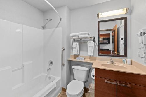 a bathroom with a toilet and a sink and a shower at MainStay Suites Spokane Valley in Spokane Valley