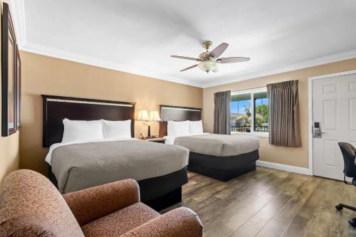 a hotel room with two beds and a couch at Quality Inn & Suites Santa Maria in Santa Maria