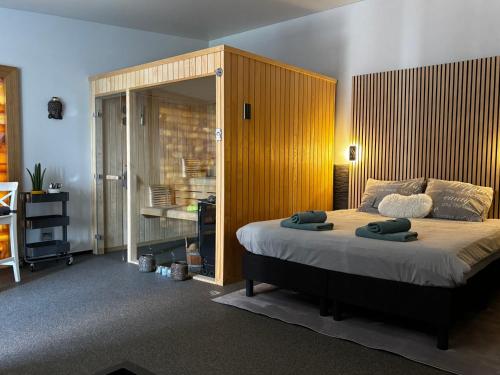 a bedroom with a large bed with a wooden headboard at Relax Trois Bornes - De Grenspost in Gemmenich