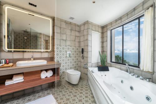 a bathroom with a tub and a toilet and a sink at Bhangeri Durbar Resort in Nagarkot