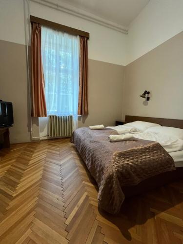a bedroom with a bed and a large window at Kiss Villa in Balatonföldvár