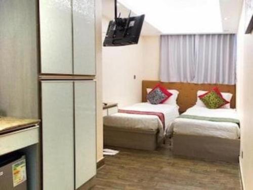 a hotel room with two beds and a tv at Metroplace Boutique in Hong Kong