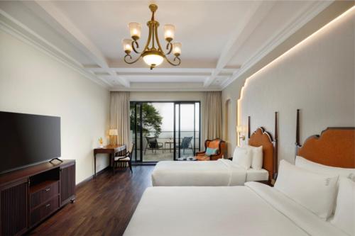 a hotel room with two beds and a flat screen tv at Bhangeri Durbar Resort in Nagarkot