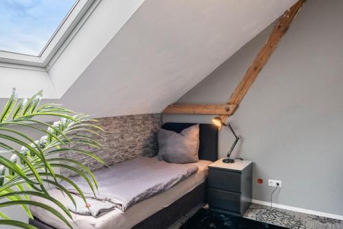a bed in the attic with a plant at Unterkunft Fischerbrücke in Wolfenbüttel