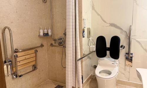 a bathroom with a shower with a toilet and a sink at Geoje Samsung Hotel in Geoje