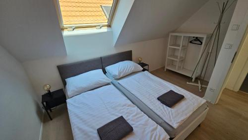 a bedroom with a bed with white sheets and a window at Rezidence Pavlov in Pavlov