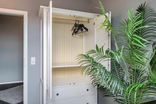 a room with a white cabinet and a plant at Unterkunft Fischerbrücke in Wolfenbüttel