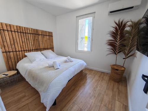a bedroom with a large bed and a plant at l'alcôve in Frontignan