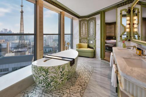 a bathroom with a tub and a sink and a chair at Shangri-La Kunming in Kunming