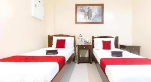 two beds in a room with red and white at Dino Residences in Daro