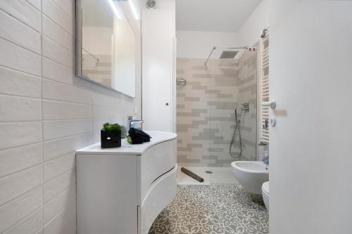 a white bathroom with a sink and a toilet at Angolo di Paradiso in Punta Ala