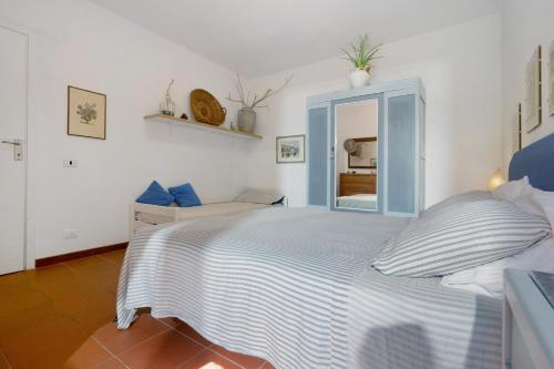 a bedroom with a blue bed with a mirror at Angolo di Paradiso in Punta Ala