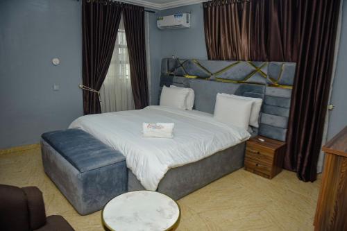 a bedroom with a large bed with a blue headboard at Living Space Service Apartment in Mama