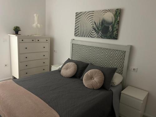 a bedroom with a bed with two pillows and a dresser at Austria 03 in Lebrija