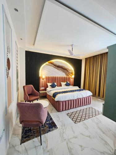 a bedroom with a large bed and a chair at Lucknow Courtyard in Lucknow