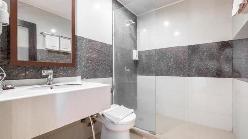 a bathroom with a sink and a toilet and a shower at Continent CentrePoint Makassar in Pampang