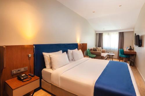 a hotel room with a large bed and a chair at Redmont Hotel Nisantasi in Istanbul