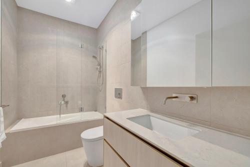 a bathroom with a sink and a toilet and a tub at Stylish 3-Bedroom Townhouse Near Shops & Parks in Point Cook