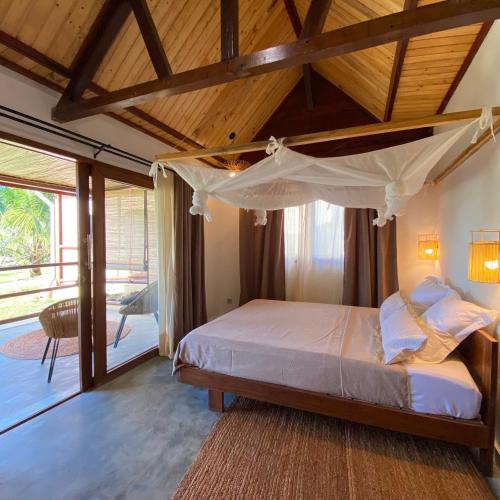 a bedroom with a large bed with a wooden ceiling at Ankavia Lodge in Sainte Marie