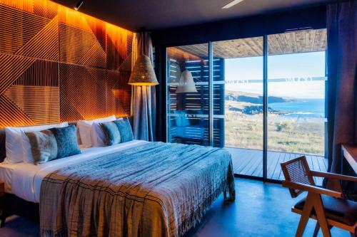 a bedroom with a large bed and a large window at Wood Hôtel & Spa in Saint-Gilles-les-Bains