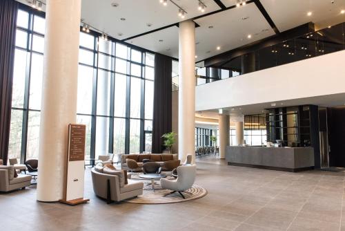 a lobby with couches and chairs in a building at Hotel Nanta Jeju in Jeju