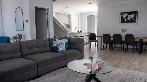 a living room with a couch and a table at Home Abroad in Ascot Park