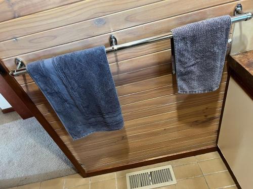 two blue towels hanging on a wooden wall in a bathroom at Sun, Sand, and Tranquility in Rye in Rye