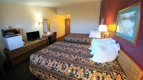 a hotel room with two beds and a television at Red Carpet Inn - Windom in Windom