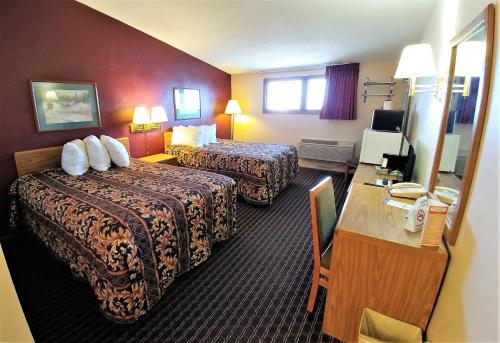a hotel room with two beds and a desk at Red Carpet Inn - Windom in Windom