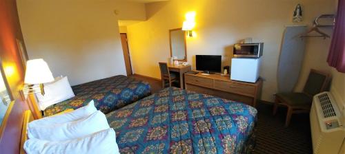 a hotel room with two beds and a television at Red Carpet Inn - Windom in Windom