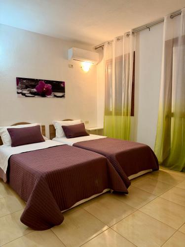 two beds sitting next to each other in a room at B&B Marku in Dëllinjë