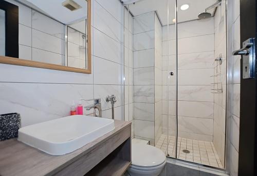 a bathroom with a toilet and a sink and a shower at Blouberg Beach Escape in Cape Town