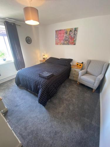a bedroom with a bed and a chair at 5 Star Large Double Room in Hull with Free Parking & WIFI in Anlaby