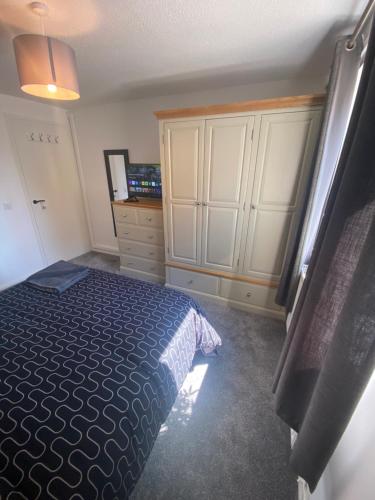 a bedroom with a bed and some white cabinets at 5 Star Large Double Room in Hull with Free Parking & WIFI in Anlaby
