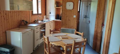 a kitchen with a table and chairs and a refrigerator at Chalet ondalis in Le Malzieu-Ville