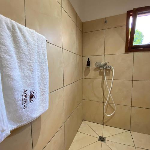 a shower with a white towel hanging on a wall at Ankavia Lodge in Sainte Marie
