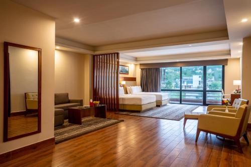 a hotel room with a bed and a living room at Avari Xpress Gilgit in Gilgit