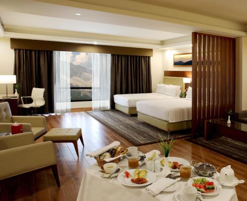a hotel room with two beds and a table with food at Avari Xpress Gilgit in Gilgit
