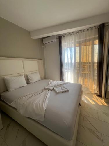 a bedroom with a white bed with a window at Maxhuri Apartments in Ulcinj