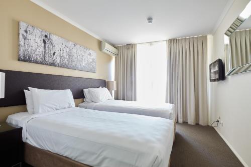 
a hotel room with two beds and a large window at West End Central Apartments in Brisbane
