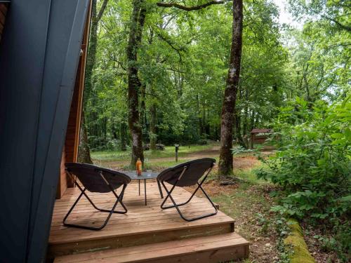 two chairs sitting on a porch with a table at La cabane en A 