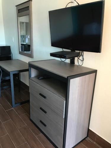 a entertainment center with a flat screen tv on top of it at Moonlight Inn & Suites in Houston